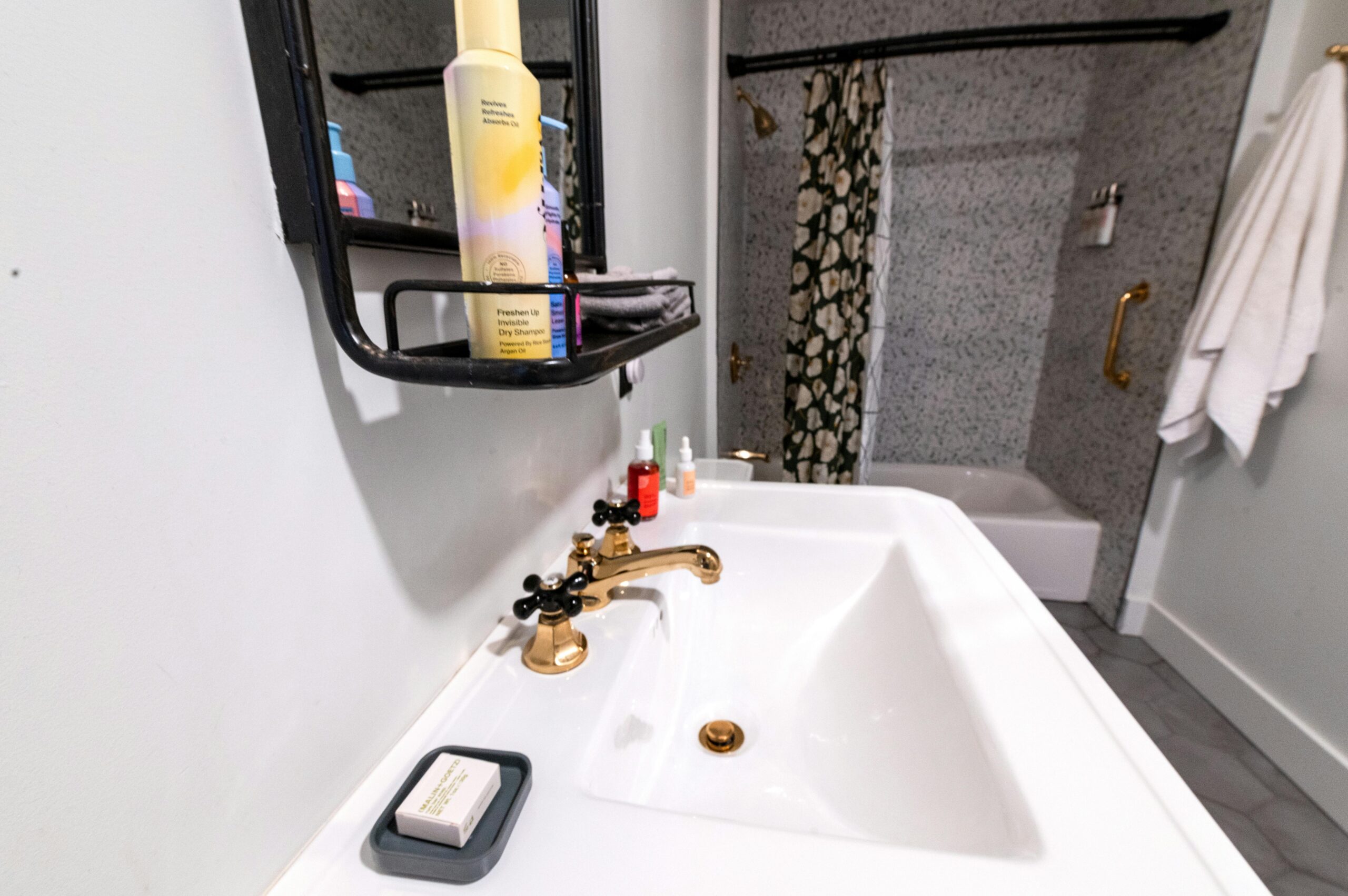 Contemporary bathroom interior featuring gold fixtures and stylish decor.